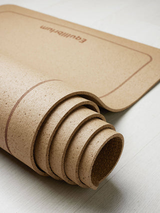 ESSENTIALS Kurk Yogamat Sugar Almond close-up opgerolde mat met logo en lijnen detail tekening