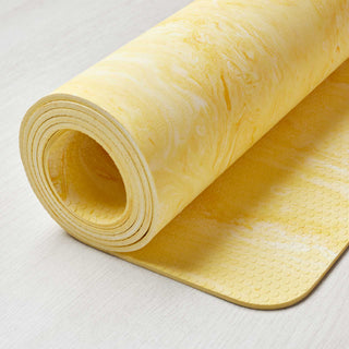 Yogamat Infinity geel met detail van grip structuur onderkant. 