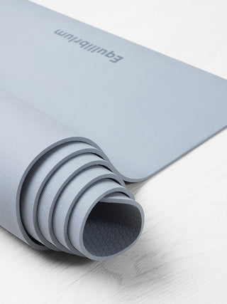 UNLIMITED yogamat licht grijs opgerold met detail van het logo